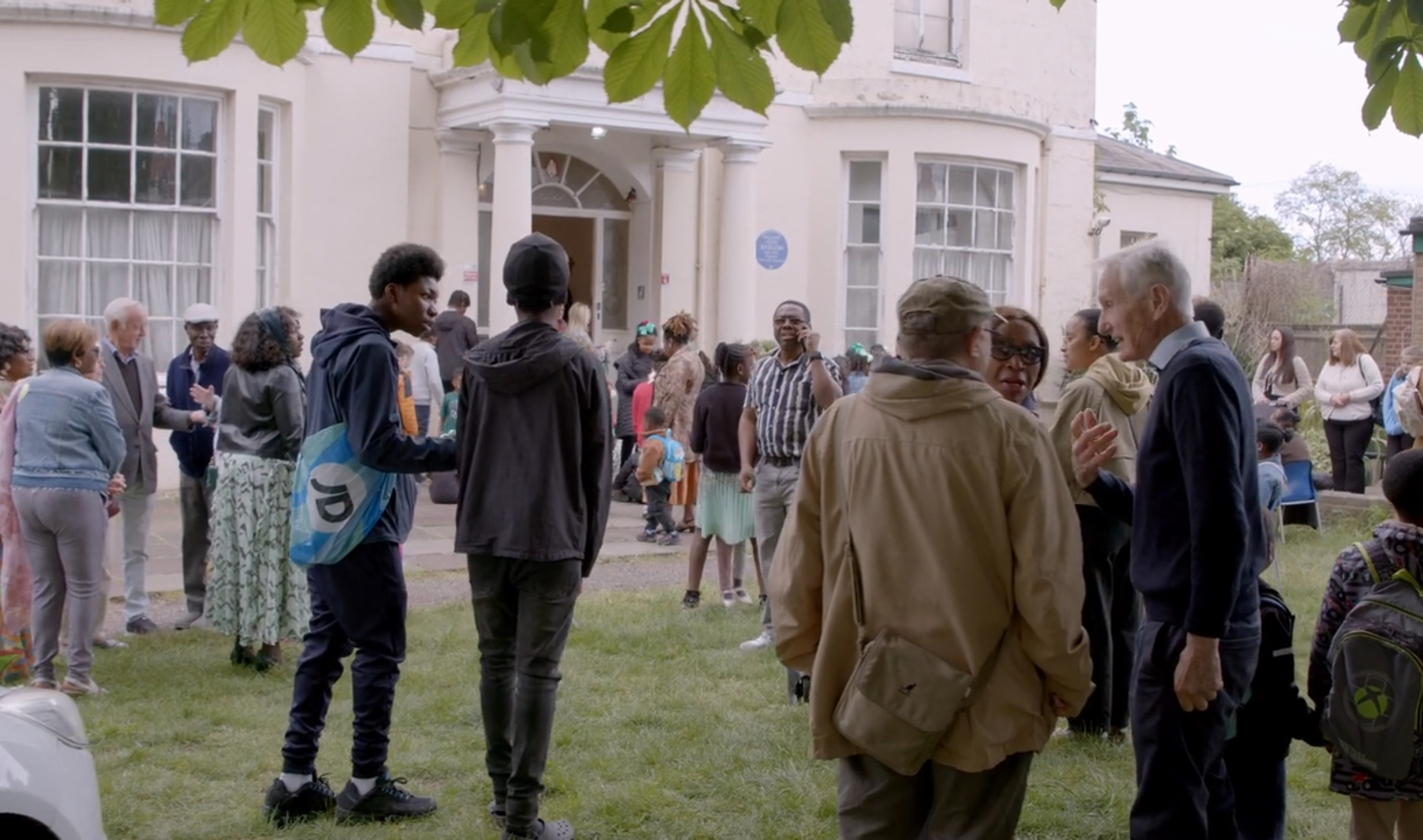 Community gathering with Highcombe House in background